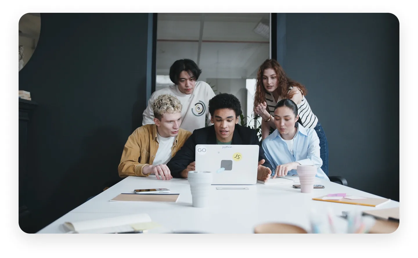 Team collaborating around a laptop